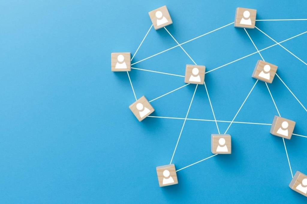 Differences Between Multi-line Phone Systems on the Market_ teamwork, network and communication concept. Wooden blocks connected together on blue background. 